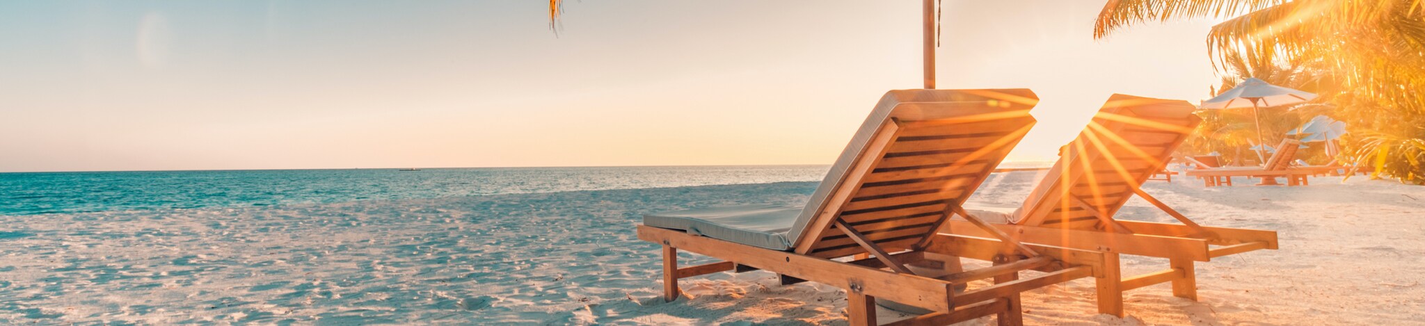 Strandliegen mit Schirm am Meer